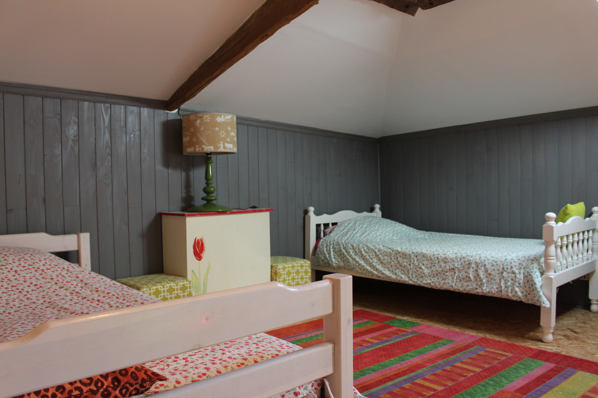 chambre avec deux lits simples, une commode et deux tables de chevets